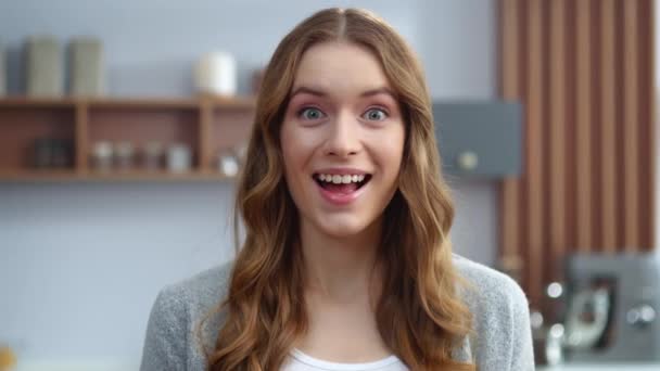 Lächelndes Mädchen zeigt Schokoriegel in der heimischen Küche. Frau schaut Kamera ins Haus — Stockvideo