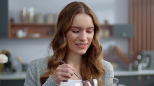 Портрет усміхненої жінки, яка їсть свіжий салат на домашній кухні. Вегетаріанська їжа — стокове відео