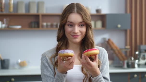 Een vrouw die binnen met taarten speelt. Grappig meisje hebben plezier met kleurrijke donuts. — Stockvideo