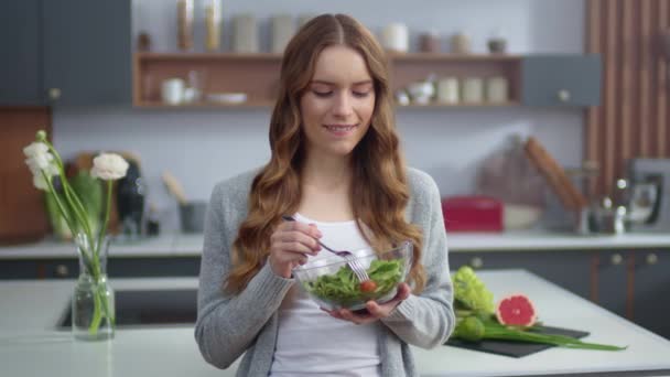 Menina bonita comer salada fresca em casa cozinha. Mulher desfrutando de comida fresca — Vídeo de Stock