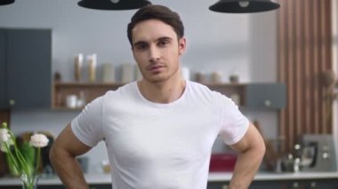 Mutfakta kameraya bakan çekici bir adamın portresi. Sportif adam eve gülümsüyor.
