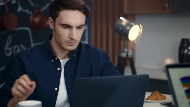 Joven hombre de negocios que usa la computadora en su oficina. Hombre enfocado trabajando en el ordenador portátil — Vídeo de stock
