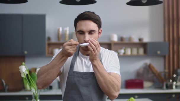 Chef homem cheirando frutos do mar em casa cozinha. Homem alegre cozinheiro desfrutando de comida dentro de casa — Vídeo de Stock