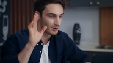 Neşeli iş adamı uzak işyerindeki dizüstü bilgisayarında video görüşmesi yapıyor..