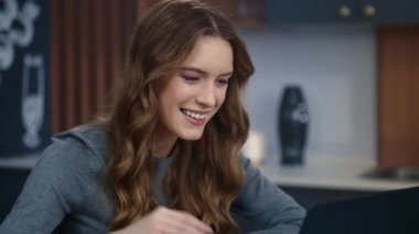 Neşeli iş kadını evdeki dizüstü bilgisayardan merhaba diyor.