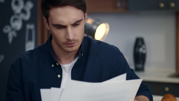 Сфокусированный бизнесмен смотрит на диаграммы в домашнем офисе. Человек читает документы — стоковое видео