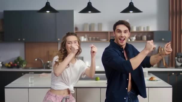 Laughing friends snapping fingers together indoors. Pria dan wanita bahagia menari — Stok Video