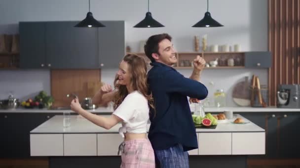 Joyeux couple dansant de retour à la maison cuisine. Amis excités s'amuser . — Video