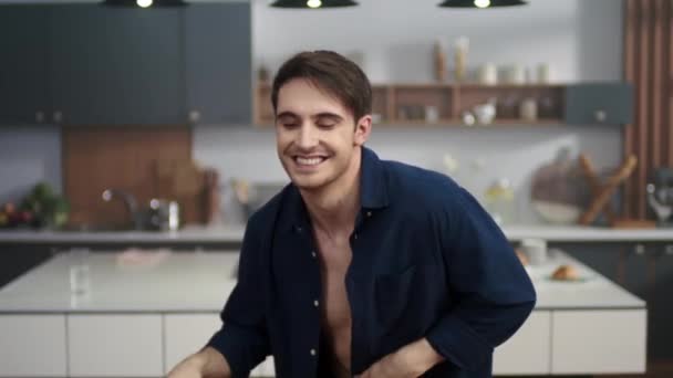 Uomo attraente che balla a casa cucina. Sexy uomo in gonna aperta in posa per la fotocamera — Video Stock