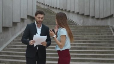 Sokakta bir kadın adama bağırıyor. İş arkadaşları kötü çalışma sonuçlarını tartışıyor