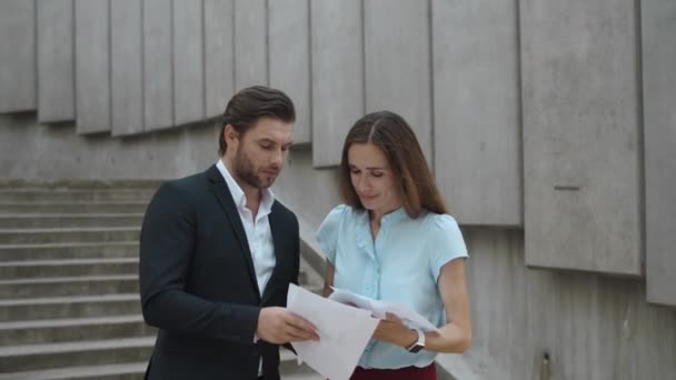 Pareja de negocios discutiendo al aire libre. Hombre de negocios lanzando documentos en el aire — Vídeos de Stock