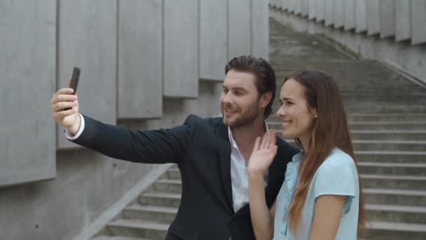 Colegas charlando en línea en el teléfono inteligente al aire libre. Hombre y mujer usando el teléfono celular — Vídeos de Stock