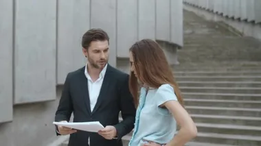 Kendine güvenen iş kadını ve işadamı şehir sokaklarında belgelerle çalışıyor.