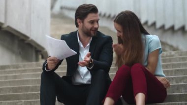 İş kadını dışarıda el kol hareketi yapıyor. İstatistikleri analiz eden iş çifti