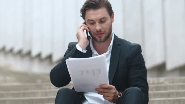 Obchodní muž mluví přes mobilní telefon.Zaměstnanec slaví vítězství s dokumenty — Stock video