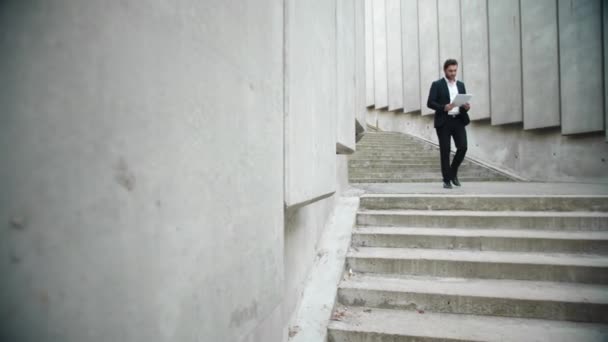 Zakenman die documenten op straat bekijkt. Mannelijke leidinggevende lopen voor vergadering — Stockvideo