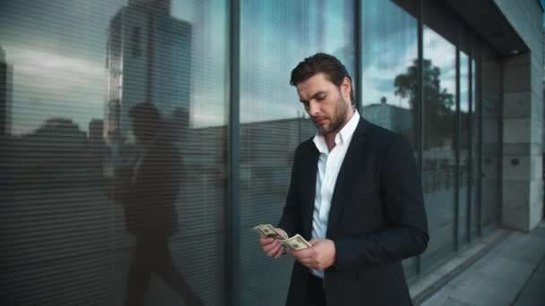 Hombre de negocios contando dinero en la calle de la ciudad.Hombre disfrutando de billetes de dólar en las manos — Vídeos de Stock