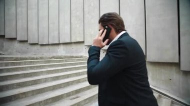 İş adamı şehirde iş arıyor. Cep telefonundan erkek profesyonel çağrı