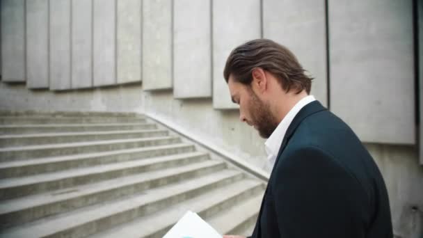 Homem de negócios a trabalhar com documentos na cidade. Empreendedor do sexo masculino subir escadas — Vídeo de Stock