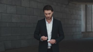 İş adamı sokakta kulaklıkla kutu açıyor. Müdür kulaklık takıyor.