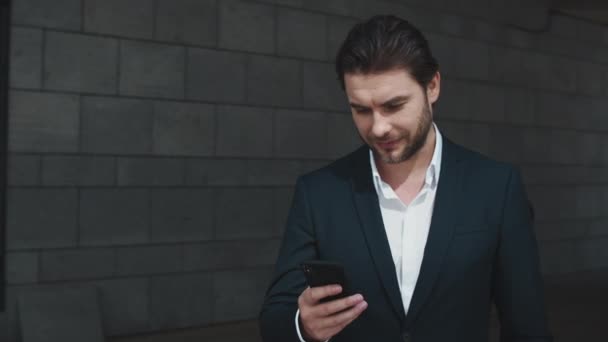 Un uomo d'affari che messaggia al cellulare all'aperto. Uomo utilizzando smartphone in città — Video Stock