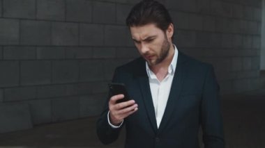 İş adamı sokakta akıllı telefon kullanıyor. Girişimci cep telefonundan mesaj atıyor.