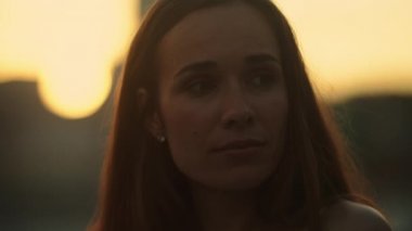 Sokakta duran düşünceli kadın. Çekici kadın şehirde günbatımının tadını çıkarıyor.