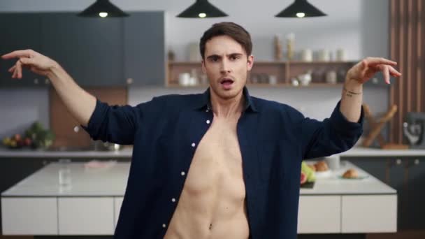 Retrato de homem sexy dançando na cozinha moderna. Sorrindo cara se divertindo dentro de casa — Vídeo de Stock