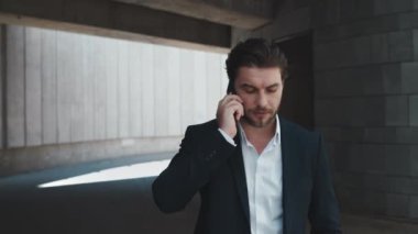 İş adamı caddede cep telefonundan arıyor. Yönetici kol saati üzerindeki zamanı kontrol ediyor
