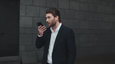 İş adamı sokakta akıllı telefonda tartışıyor. İş adamı cep telefonuyla yazıyor.