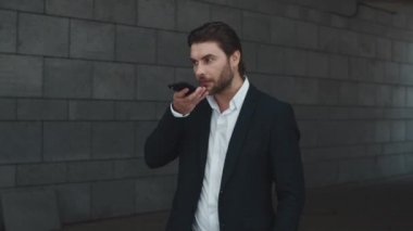 İş adamı caddede hoparlörden konuşuyor. Sokakta dikilen adam