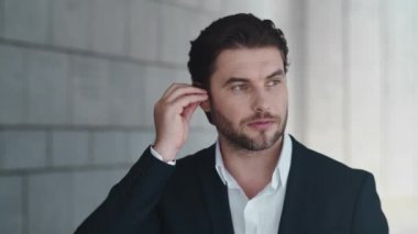 İş adamı şehirde kablosuz kulaklıkla konuşuyor. Kulaklık kullanan bir çalışan.