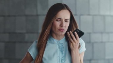 Memnuniyetsiz iş kadını şehirdeki cep telefonundan sesli mesaj kaydediyor.