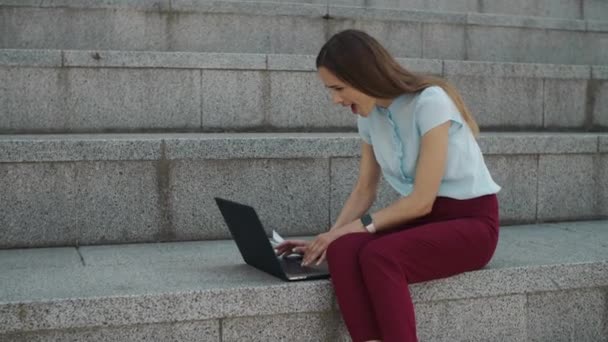 Mujer de negocios leyendo buenas noticias en el portátil. Trabajador celebrando el éxito en la ciudad — Vídeo de stock