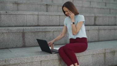 İş kadını laptoptan iyi haberler okuyor. Akıllı telefondan konuşan kadın işçi.