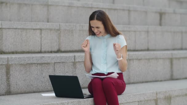 Mujer de negocios leyendo buenas noticias en el portátil. Gerente celebrando la victoria al aire libre — Vídeos de Stock