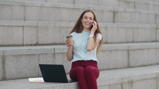 Zakenvrouw aan het praten op smartphone in de stad. Executive drinken take away koffie — Stockvideo