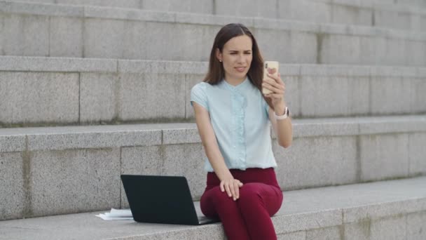 Affärskvinna som har videochatt på smartphone. Manager använder telefon utomhus — Stockvideo