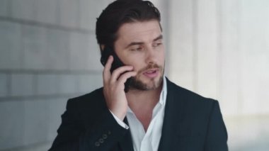 İş adamı sokakta telefonla konuşuyor. Çalışanların kol saati üzerindeki kontrol süresi