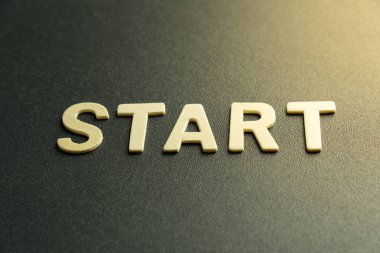 Kelimenin ahşap harfi siyah arkaplanda başlar