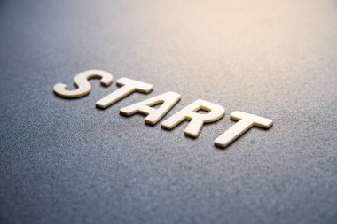 Kelimenin ahşap harfi siyah arkaplanda başlar