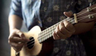 genç kadın ukulele üzerinde oyun görünümü kapatın