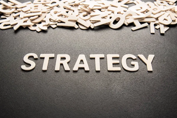 Siyah arkaplanda STRATEGY sözcüğünün ahşap harfi