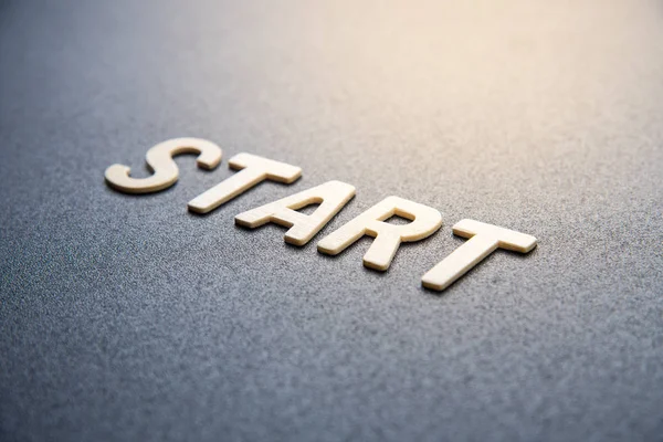 Kelimenin ahşap harfi siyah arkaplanda başlar