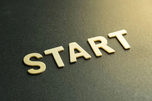 Kelimenin ahşap harfi siyah arkaplanda başlar