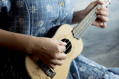 genç kadın ukulele üzerinde oyun görünümü kapatın