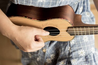 genç kadın ukulele üzerinde oyun görünümü kapatın
