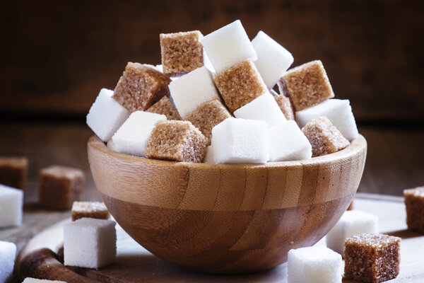 Refined sugar cubes, vintage wooden background