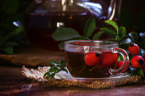 Healing black tea with wild rose berries in a glass cup