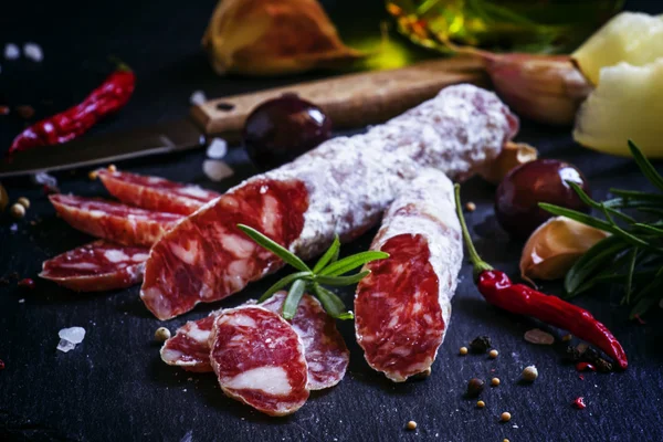 Salami italiano con romero, especias, aceitunas y aceite . — Foto de Stock